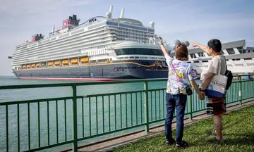 Two passengers pose for a photograph ahead of the Disney Adventure’s maiden voyage on March 10. The cruise will roll out a US$5 (S$6.40) delivery charge for in-room dining orders from June 4.