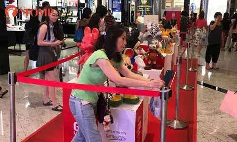 Even a cordon can't stop this woman from taking selfies with Mickey Mouse display at Raffles City