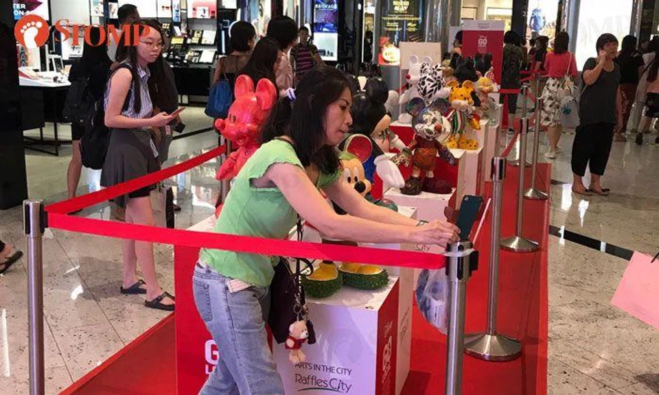 Even a cordon can't stop this woman from taking selfies with Mickey Mouse display at Raffles City