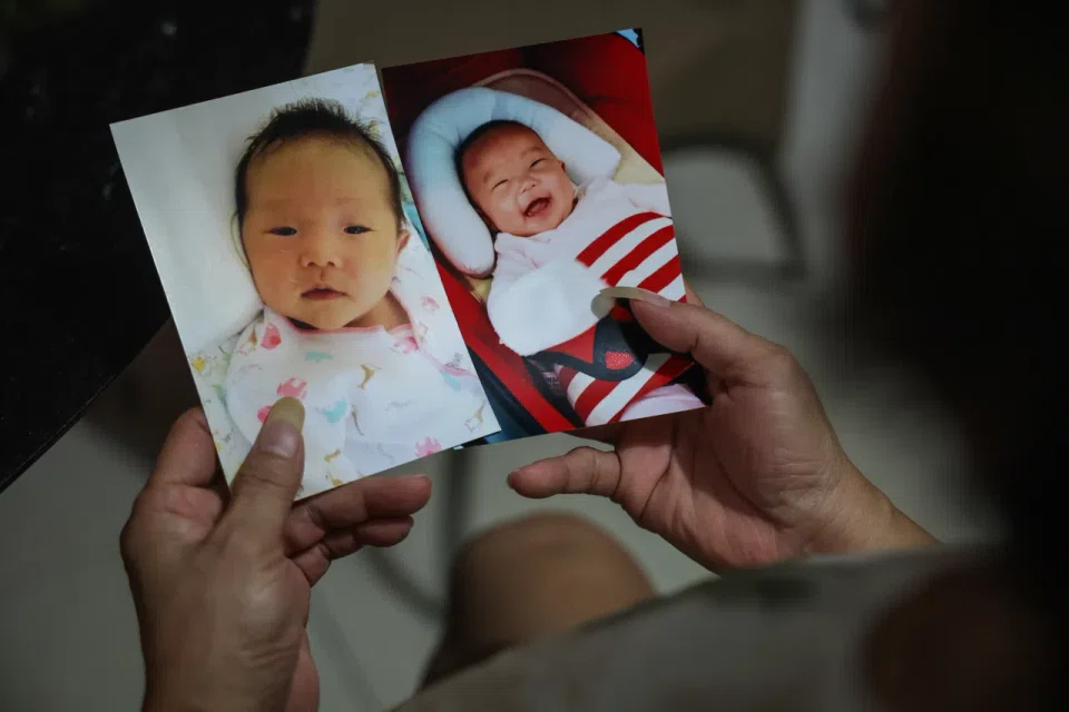 Madam Chua looking at baby photos of her late granddaughter, Megan Khung.