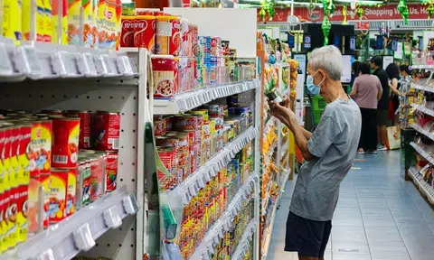 An old man looking at canned food at a shelf at the supermarket