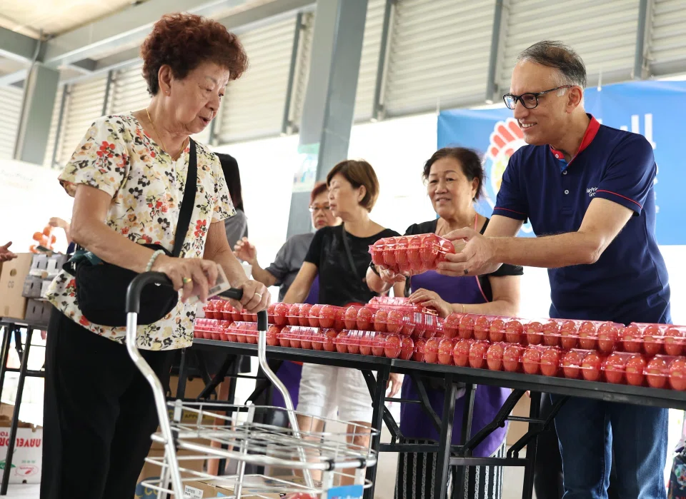 Mr Vipul Chawla (right), group chief executive of FairPrice Group, handing out eggs to beneficiaries on March 22.