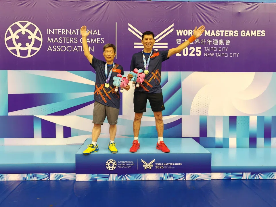 Singapore's Victor Sim (right) and his badminton men's doubles 70+ partner Yang Zhen Xing on the podium after clinching gold.