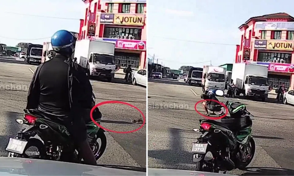 The motorcyclist dismounted his vehicle to save the kitten.