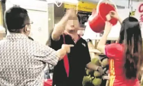 The stall owner (middle) told his assistant (rightmost) to return the money to the customer (leftmost). Photo: Lianhe Wanbao