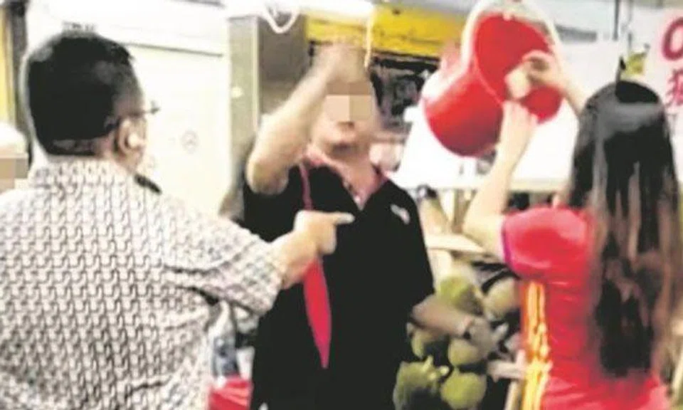The stall owner (middle) told his assistant (rightmost) to return the money to the customer (leftmost). Photo: Lianhe Wanbao