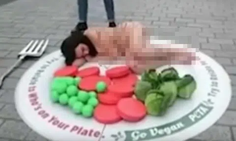 Woman sheds clothes and covers herself in gravy to pose as turkey meal in animal rights protest