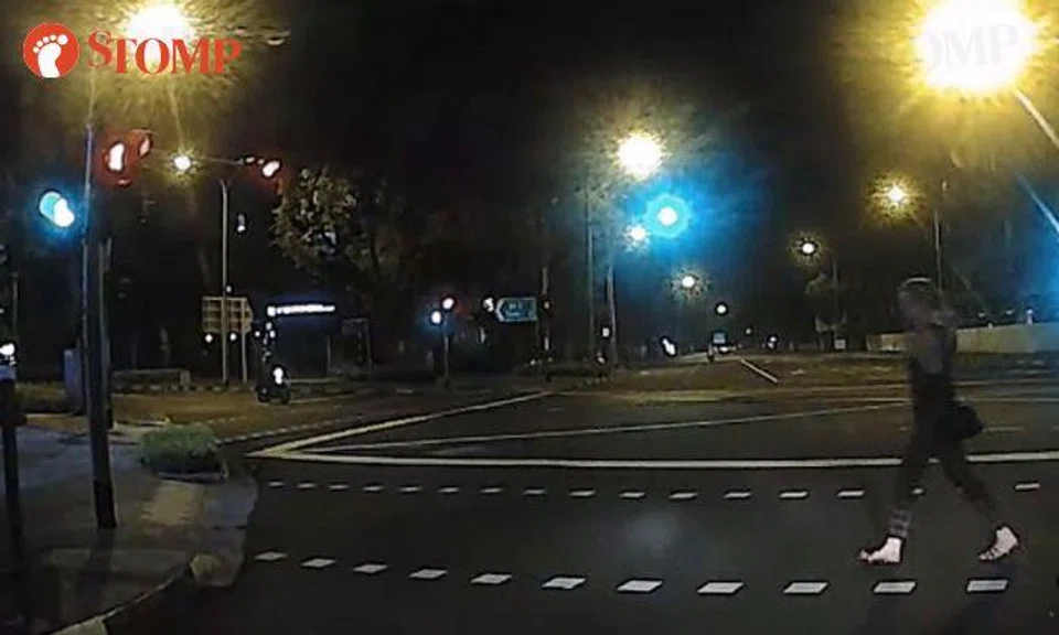 Woman endangers her life by crossing road when red man is showing