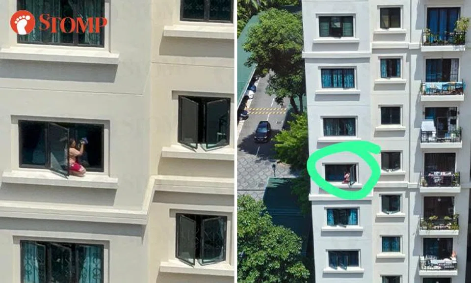 A woman was seen squatting on a ledge to clean windows at a condominium in Alexandra Road. 