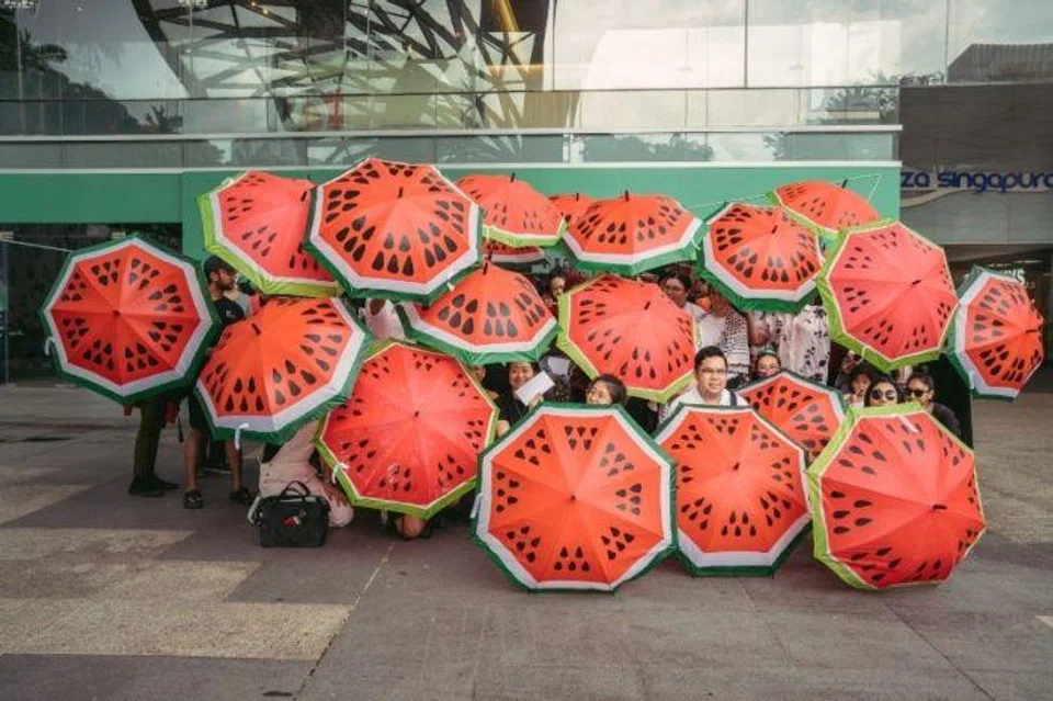 Posing with watermelon umbrellas outside Plaza Singapura