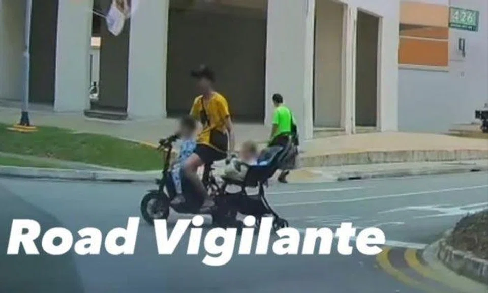 Man rides PMD while dragging baby pram along at Jurong West carpark