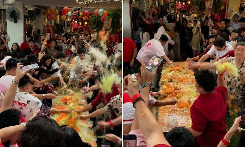 attendees throw handfuls of yusheng at chinese new year celebration