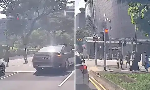 BMW driver pushes through crowd of pedestrians crossing road in Orchard
