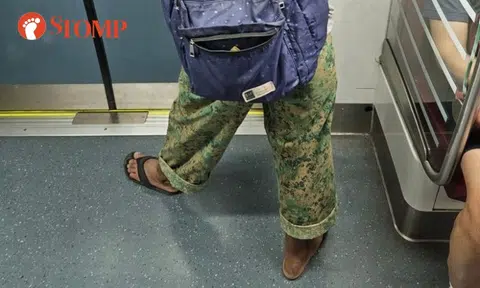 Man on train wears army pants with civilian clothes even though half uniform not allowed