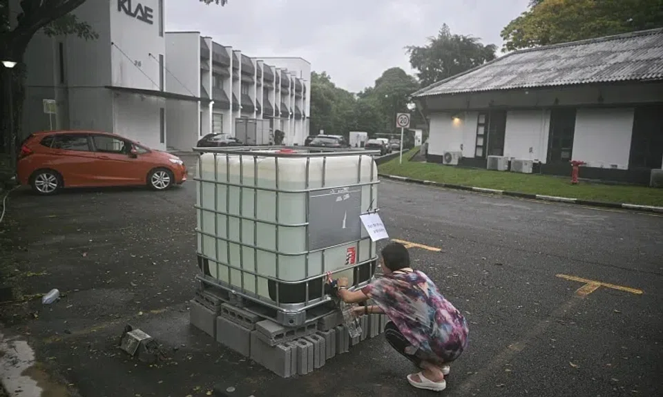 Ms Lim, a tenant and owner of a yoga studio, collecting water from a water tank to use for flushing, in Phoenix Park on Jan 13.