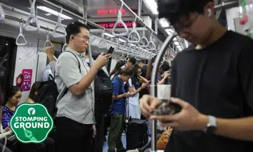 people on train, priority seat taken, using phones