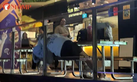 Teen couple lie on each other at Our Tampines Hub as onlookers stare