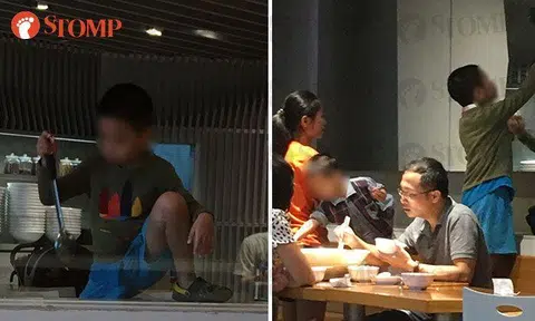 The unruly boy climbing over a counter and playing with a ladle (left) while his family (right) continued eating. 