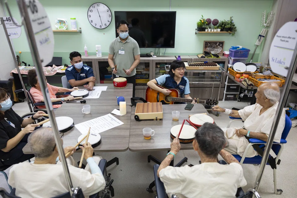 Mr Bakti Khair (standing) helping to conduct a music therapy session with dementia patients during his clinical placement at St Luke's Hospital.