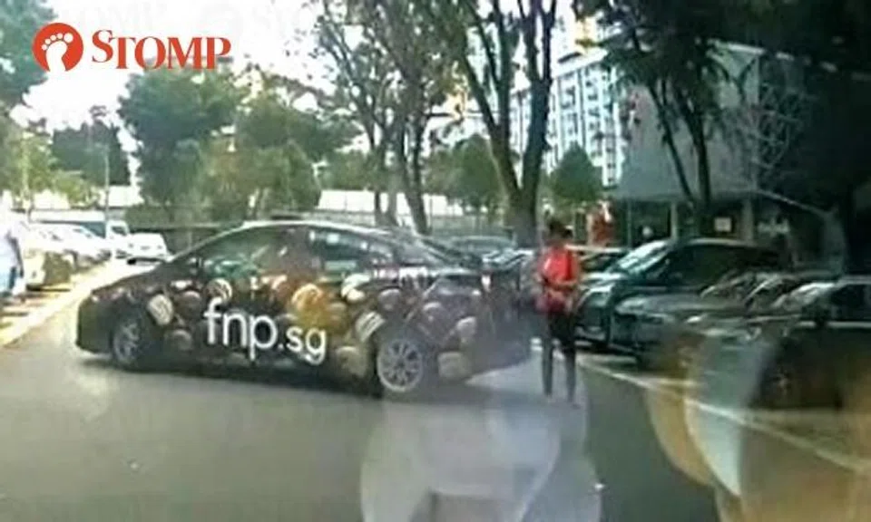 Taxi reverses into woman allegedly 'choping' parking lot with her body in Ang Mo Kio
