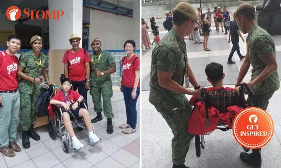 Army officers escort boy in wheelchair from school to Padang so he can watch NDP rehearsal