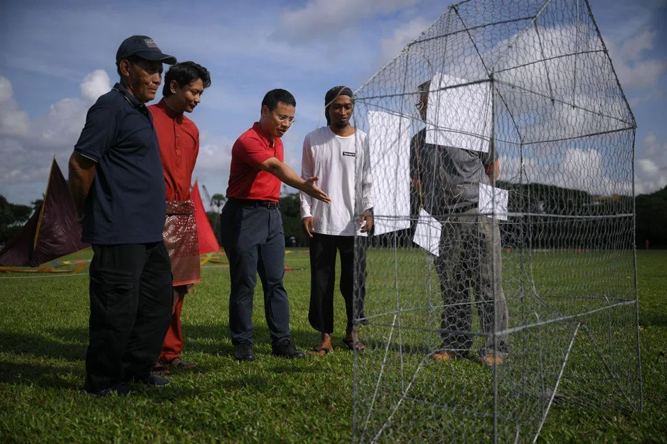 Mr Desmond Lee (third from left), Minister for Education, and Mr Firdaus Sani (second from left), founder of Orang Laut SG, tour a display of traditional fish traps at West Coast Park.