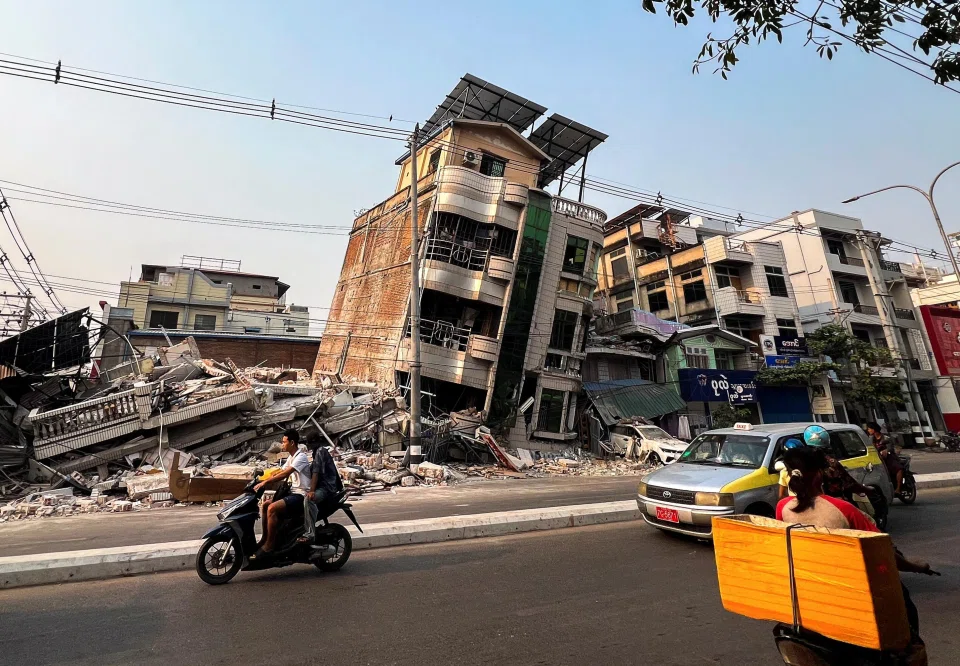 Motorists driving past a building in Mandalay, Myanmar, that collapsed in a strong earthquake.