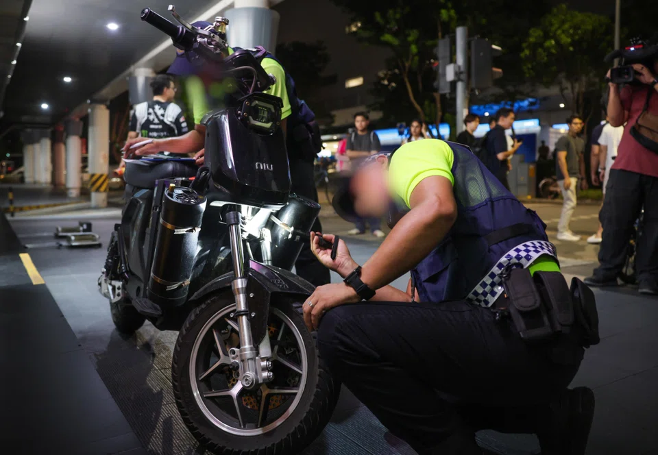 LTA enforcement officers inspecting a suspected non-compliant PMD during the enforcement check in Yishun on Aug 3.