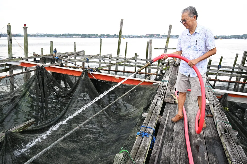 Mr Timothy Ng washing the nets of kelong E63, which he purchased in 2004.
