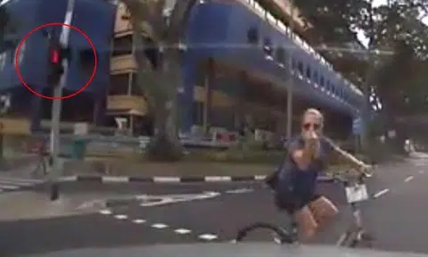 Cyclist beats red light, doesn't dismount when crossing road -- yet gives driver the finger 