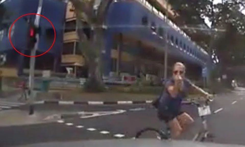 Cyclist beats red light, doesn't dismount when crossing road -- yet gives driver the finger 