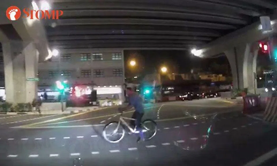 Cyclist takes his time to cruise across Cantonment Road even though red man is showing