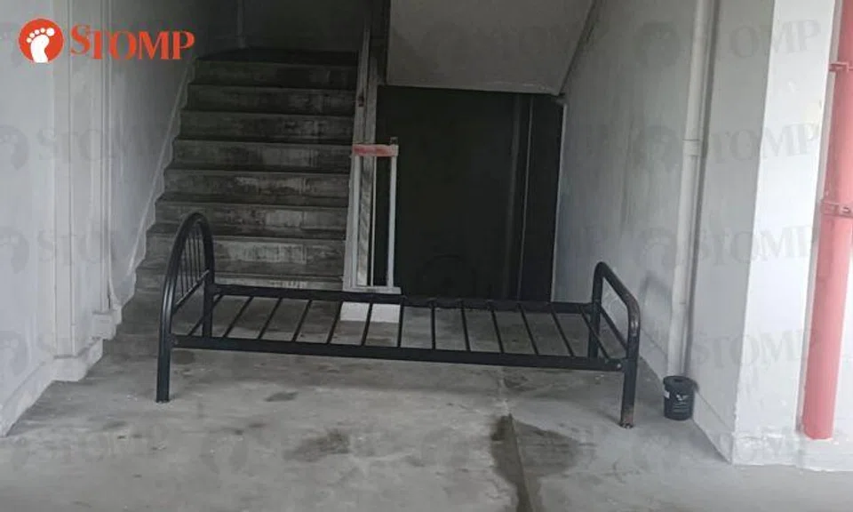 Discarded bedframe obstructs Bedok staircase, adds to cleaner's workload, inconveniences residents
