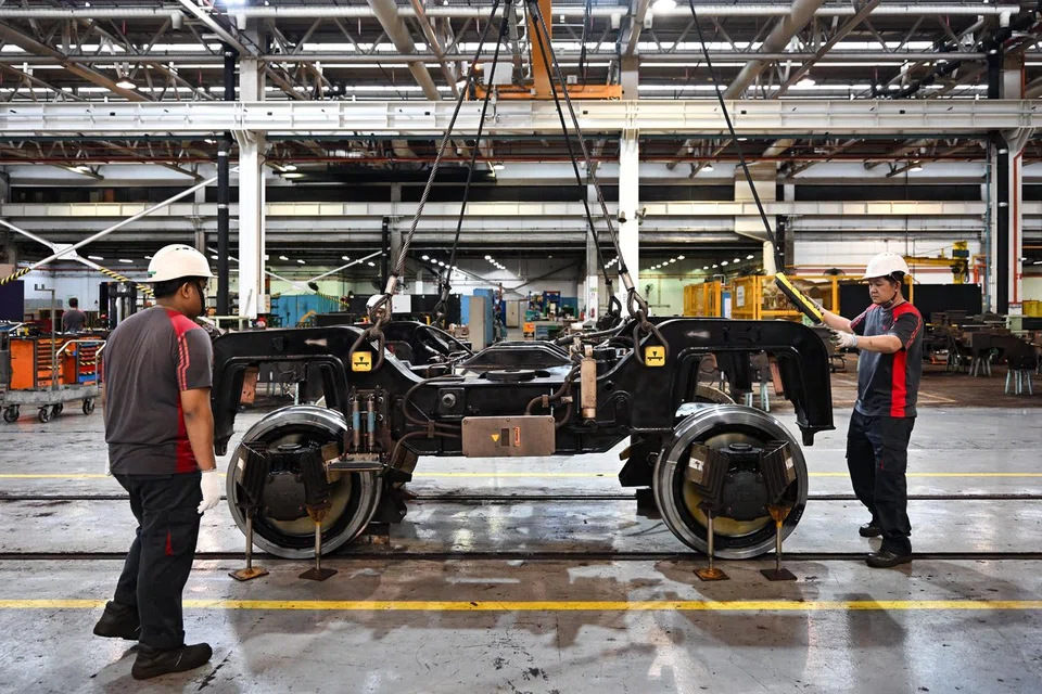 Technical officers putting the bogie frame onto a wheelset inside the workshop at Bishan Depot on March 11, 2025.