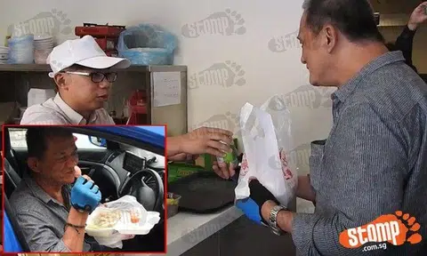 Staff at The Yang's Traditional Hainanese Chicken Rice giving cabby Yu Fook Wah free chicken rice and a canned drink.