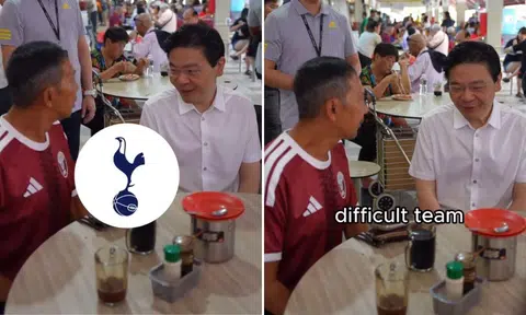 Prime Minister Lawrence Wong chatting with a man in red