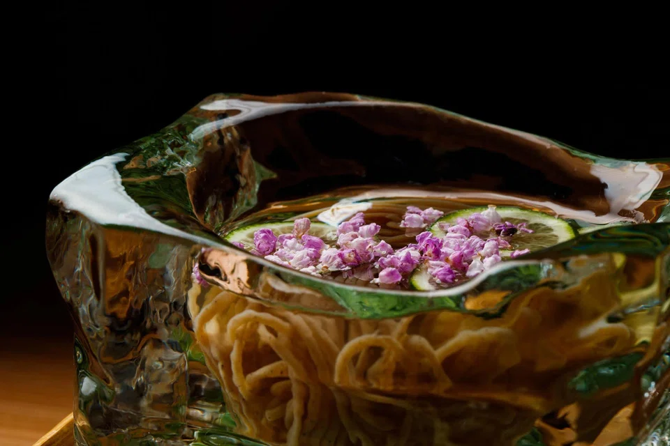 Kudzu (a type of vine) somen served in a hand-chiselled block of ice. 