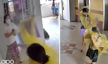 woman spraying insecticide at people in raincoats