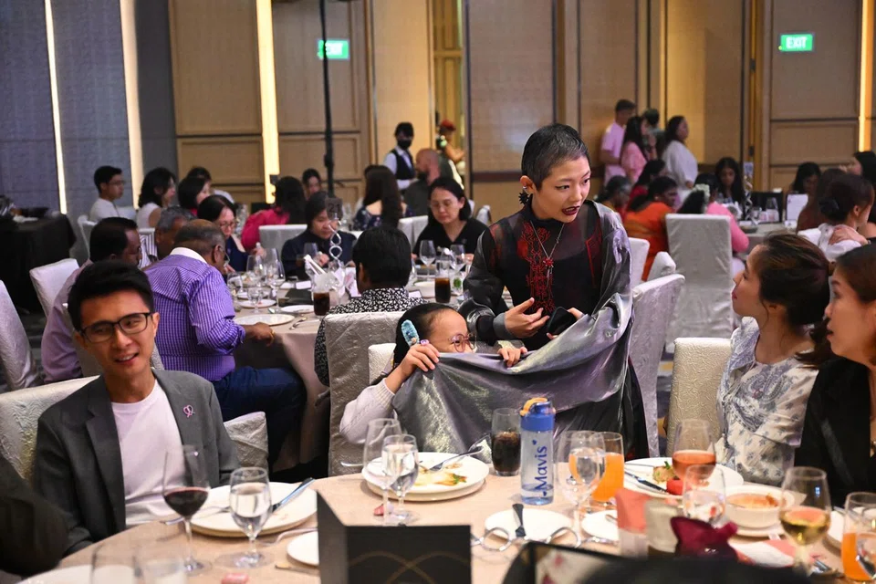 Attending the Courage Catwalk 2025 fashion show are Ms Lim's husband Chong Ser Jing (left) and niece Mavis Tan, who is intrigued by her costume.