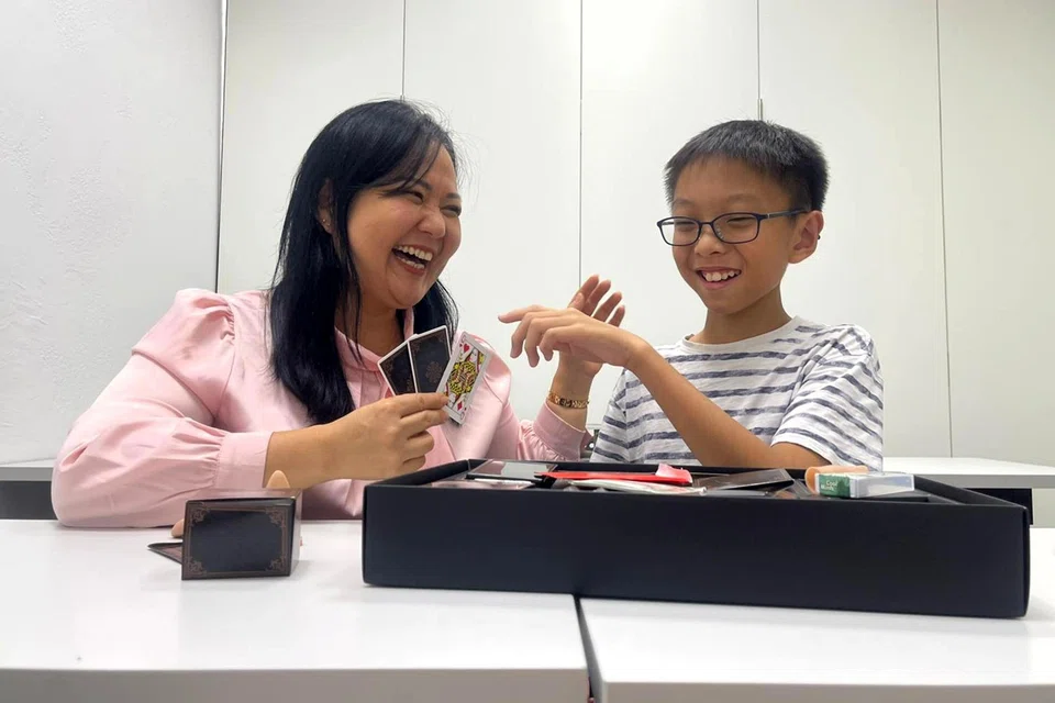Ms Laura Oh, founder of House of Hows education centre and an advocate for play, amuses Primary 6 pupil Keegan Tan with magic tricks during a lesson break.