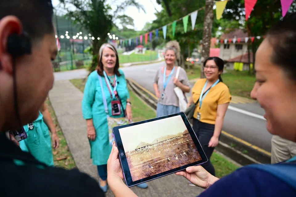 Participants looking at a photo of the old Dempsey Hill during The Spooky Tours at Dempsey Hill in August 2024.