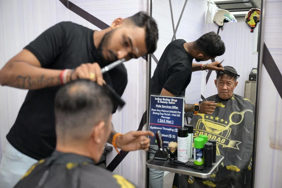 Mr Kabilanraj Silvarajah, a barber at the Indian Barber Shop, giving Mr Lee Liaw Boon a haircut on March 7.