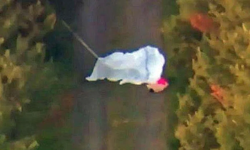 Photo: 7 News. One of the deceased lying on the ground, with parachutes having been deployed.