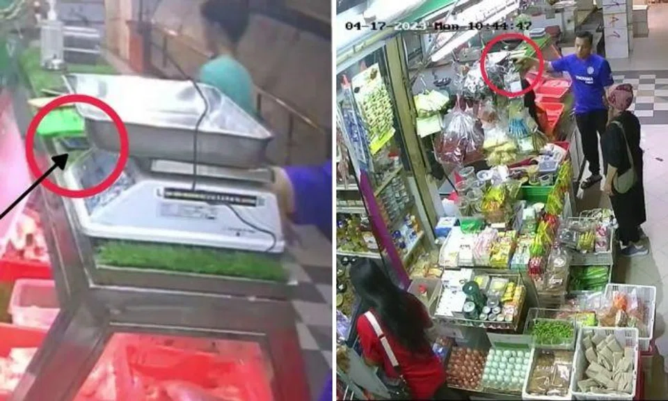  a blue Chelsea Football Club shirt at the stall taking the phone next to a weighing scale on the counter.