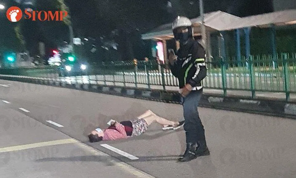 woman lying middle of road yishun