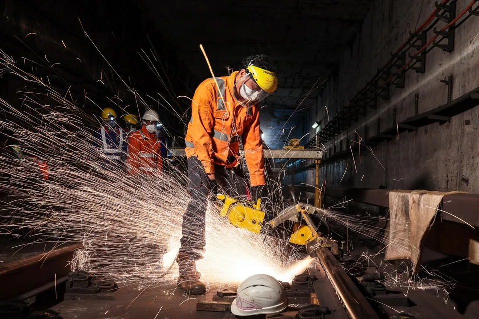 A worker cutting a faulty 18m rail segment from the tracks. The team of 13 to 14 workers will then weld the new rail segment to close the gaps with the adjacent segments. 