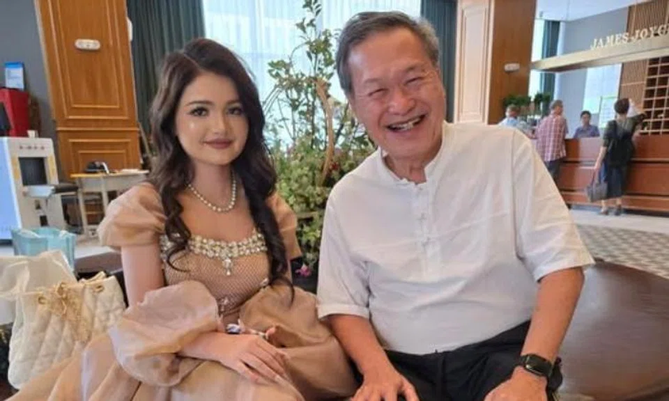 Mr Tan Kin Lian grinning beside a young woman, whom he describes as a Uyghur beauty who is "not only pretty, but friendly".