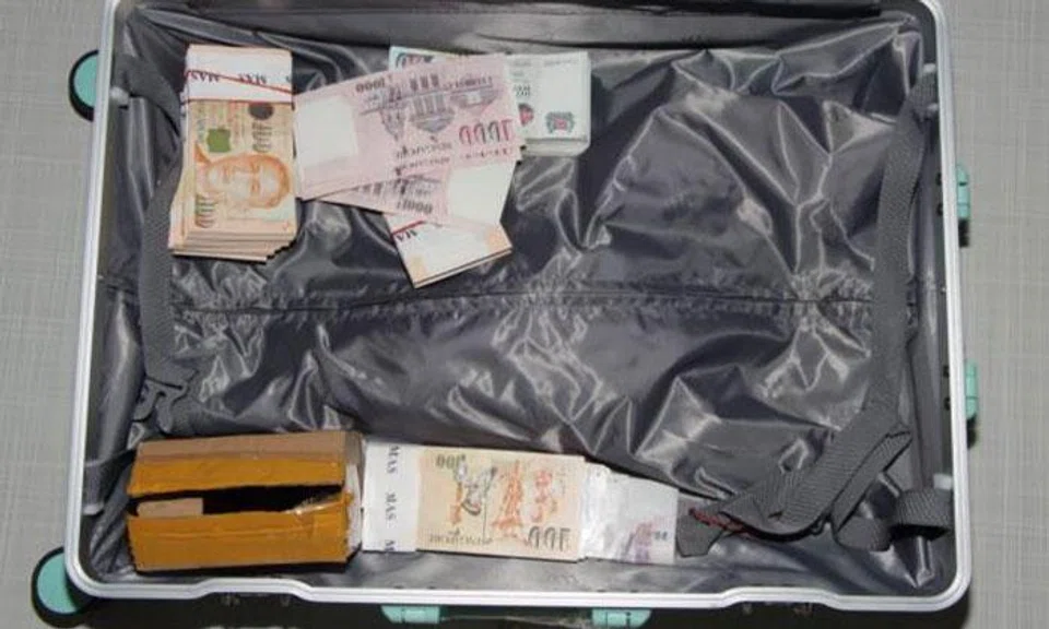 Officers seized items including over $88,000 in cash and two motor vehicles with a combined value of more than $1 million. PHOTO: SINGAPORE POLICE FORCE