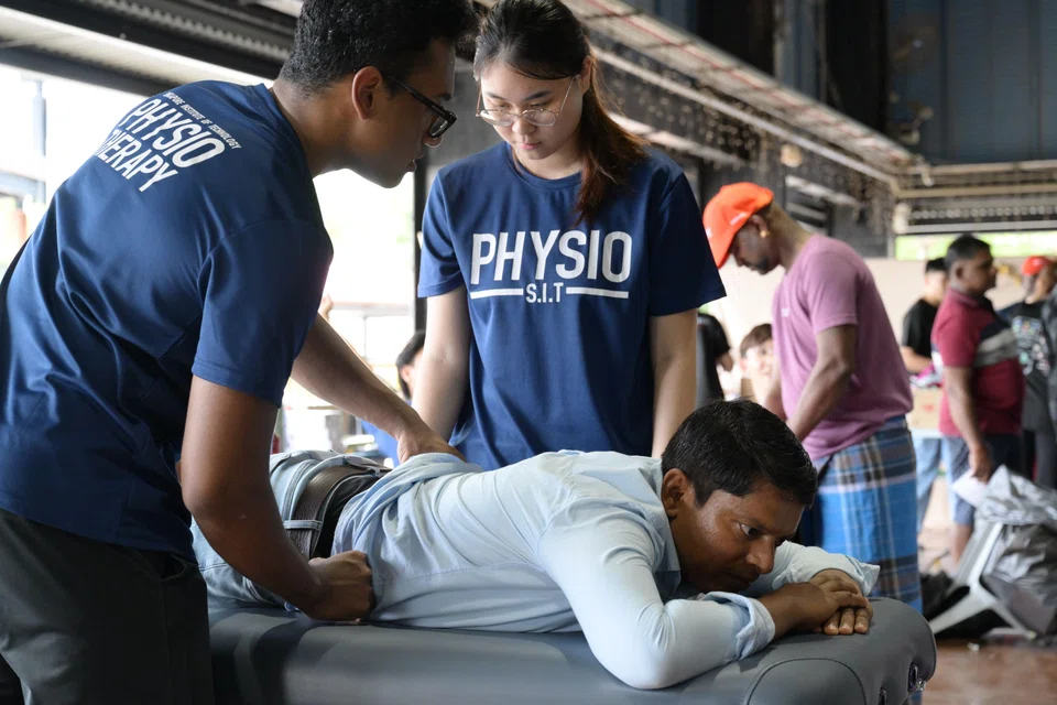 Migrant workers receiving free physiotherapy sessions from students at Singapore Institute of Technology on World Mental Health Day at Terusan Recreation Centre on Oct 5.