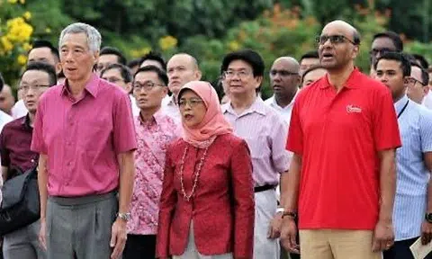 Prime Minister Lee Hsien Loong, President Halimah Yacob and Senior Minister Tharman Shanmugaratnam singing the national anthem with staff from Istana, PMO, and Military Police during the National Day Observance Ceremony at the Istana on 8 Aug 2019. Photo: The Straits Times